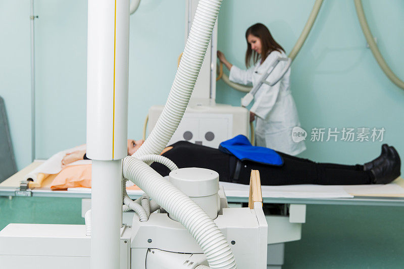 年轻女子正在做x光检查…两名放射科医生在准备检查