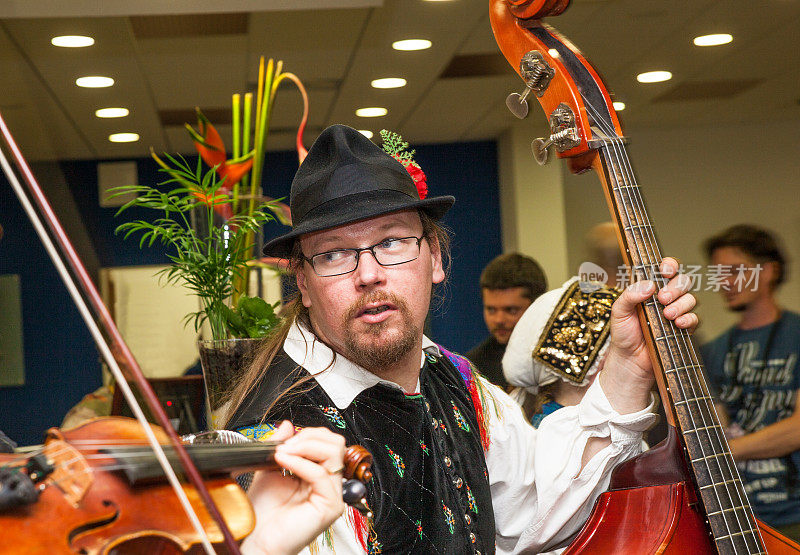 男低音提琴手穿着斯洛文尼亚传统服装在室内现场表演