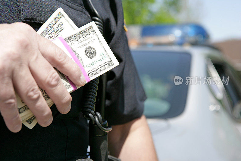 警察拿着钱堆的概念形象的腐败