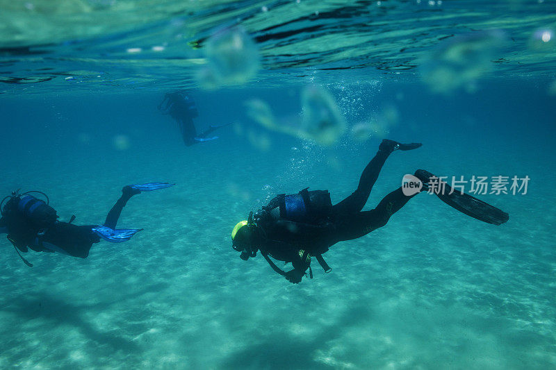 两名潜水员在蓝色泻湖中潜水