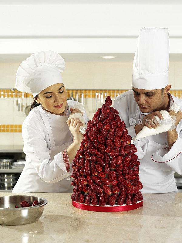 厨师在商业厨房创造草莓金字塔
