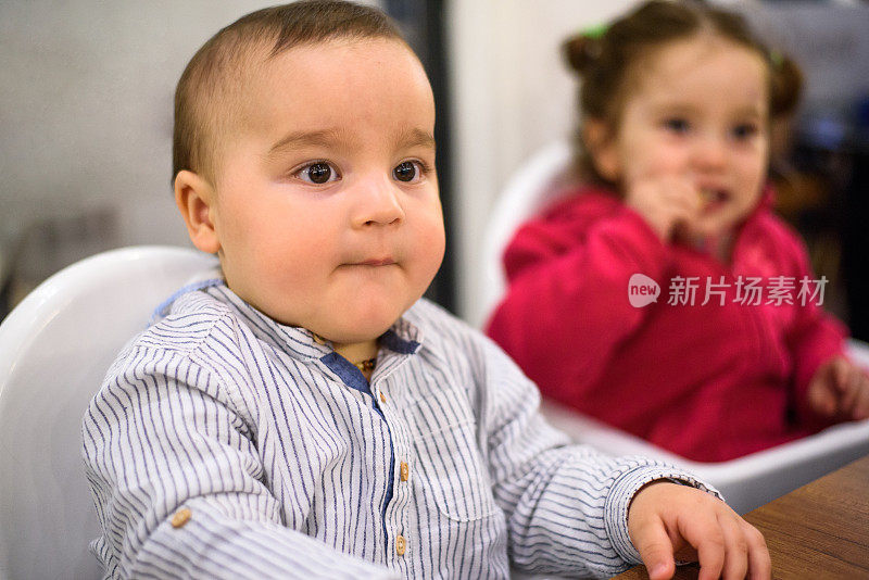 小男孩在餐厅的高脚椅上