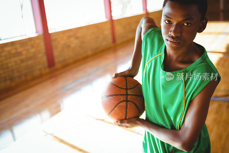 一个十几岁的男孩拿着篮球