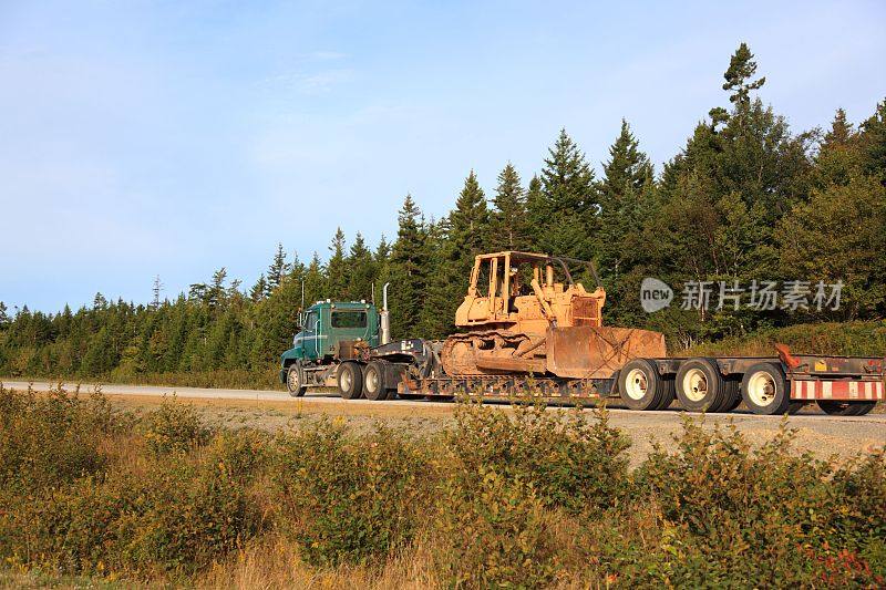 公路上拖着推土机的半挂车