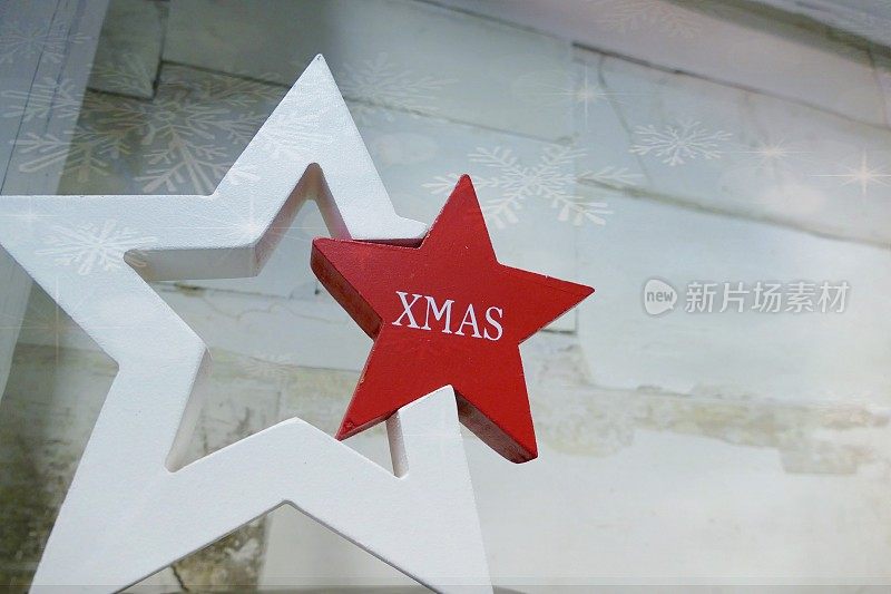 红白相间的圣诞明星站在白色破旧别致的墙前