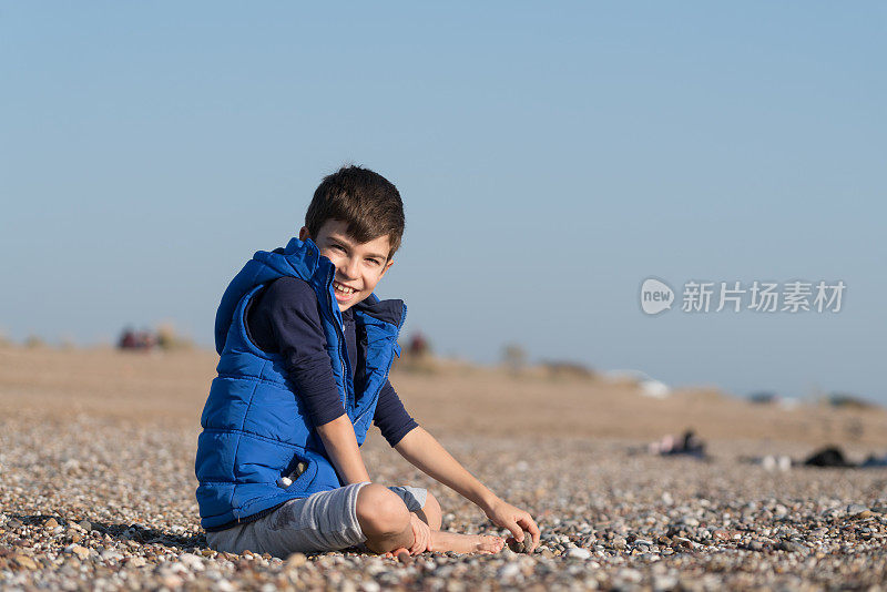 快乐的男孩在一个冬天的一天在沙滩上玩