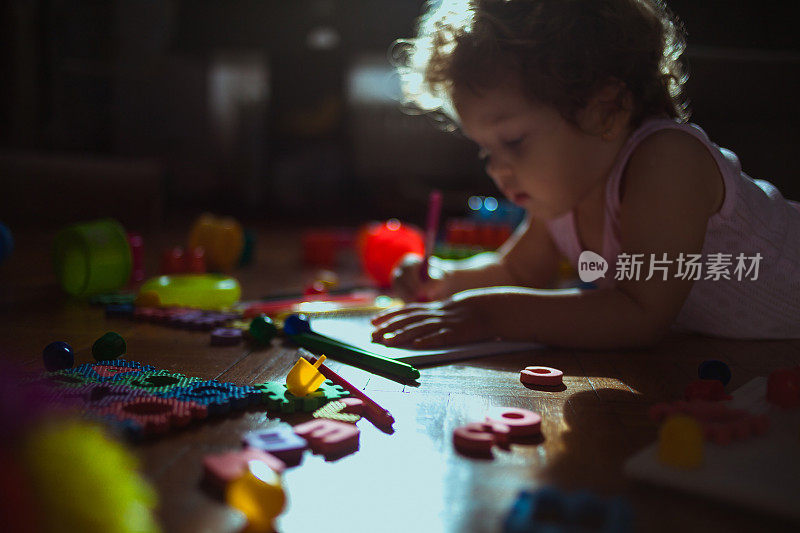 小女孩在地板上玩玩具