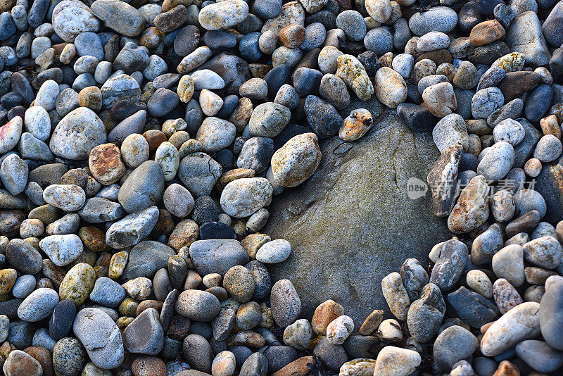 一块大石头被许多小石头包围着
