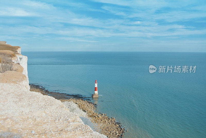 鸟瞰图海滩头灯塔与蓝色的水在英国海峡的背景和白色白垩石的悬崖，七姐妹郊野公园，东苏塞克斯，英格兰，英国。