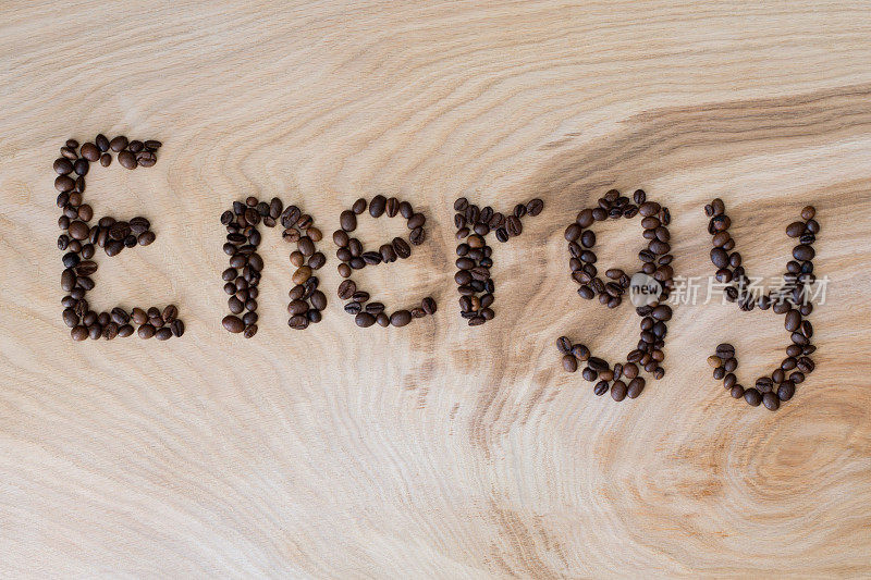 文字能量从咖啡颗粒在木制的背景