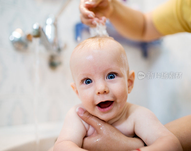 快乐的宝宝在洗澡。浴缸里的小孩。在浴室里微笑的孩子。婴儿洗浴。卫生和幼儿护理。