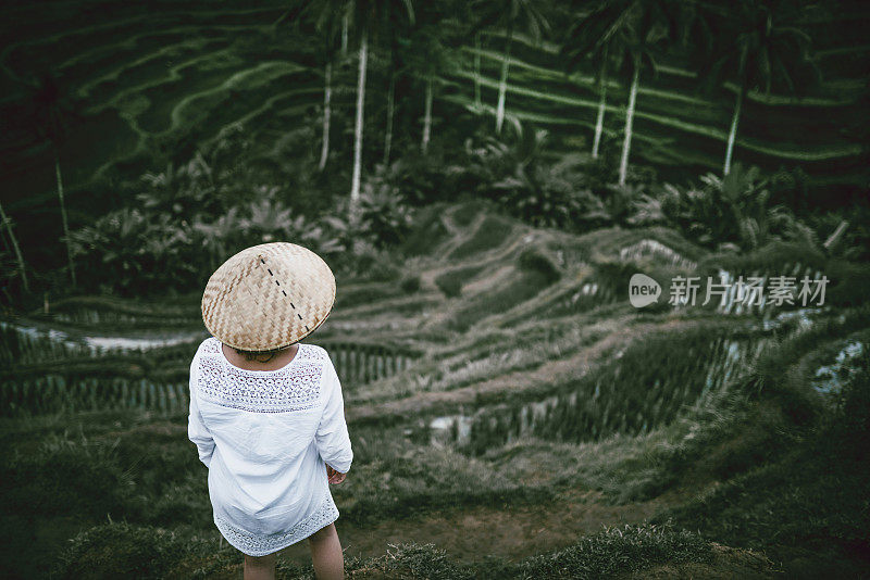 亚洲女性与传统草帽看稻田
