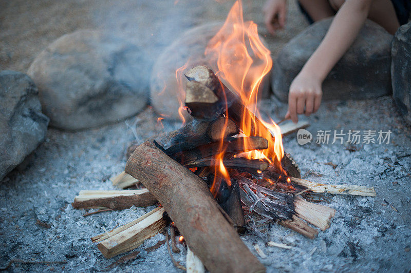 在营火中用石头玩棍棒