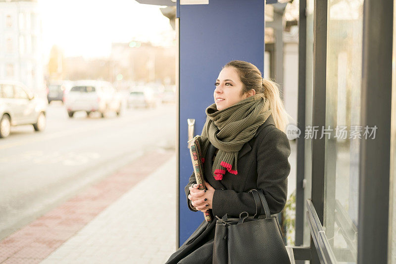 一位年轻女士在汽车站等车