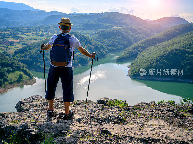 一个徒步旅行者站在山顶欣赏风景