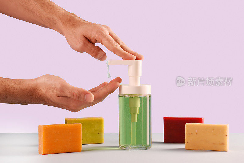 概念肥皂，一个男性的手使用肥皂液和多色肥皂棒
