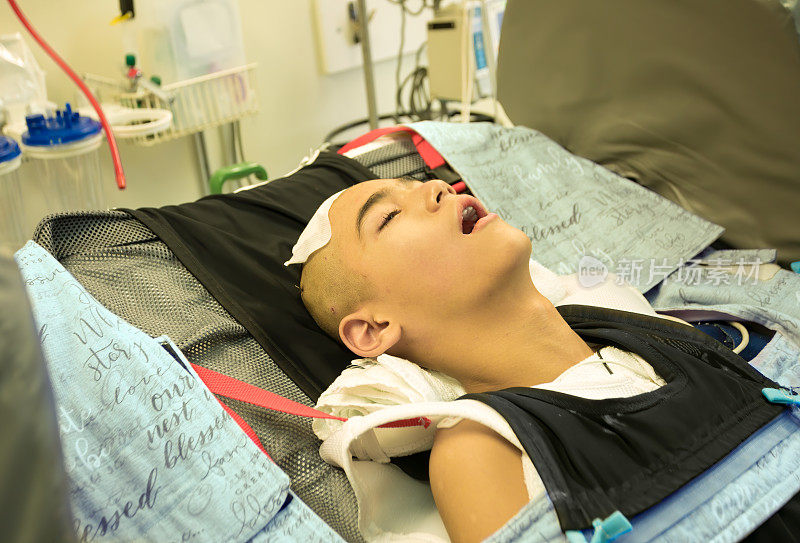 一名头部手术后昏迷在医院病床上的残疾少年