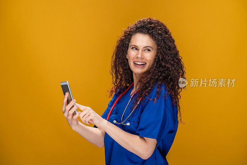 年轻女医生，带着智能手机，黄色背景