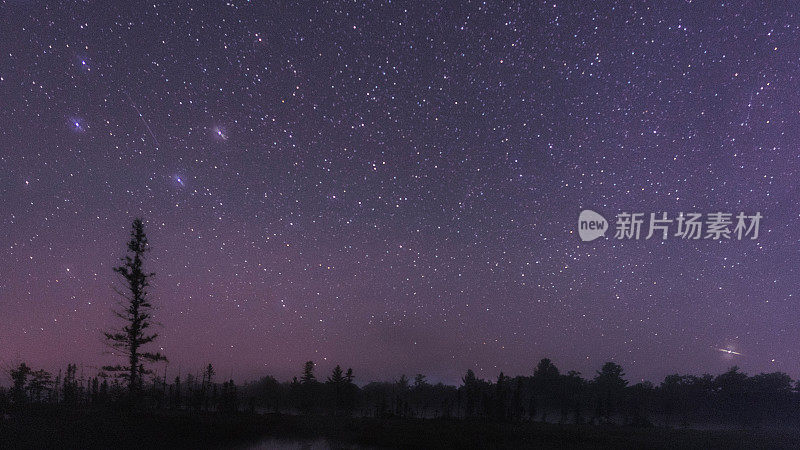 加拿大安大略省托伦斯黑暗天空保护区的夏夜天空中，银河和星星倒映在平静的湖面上