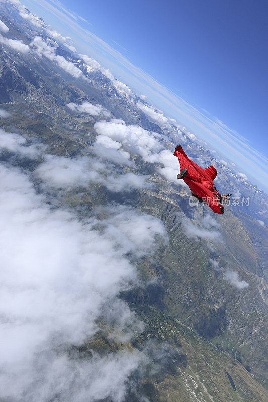 翼装飞行员滑翔穿过高高的云层
