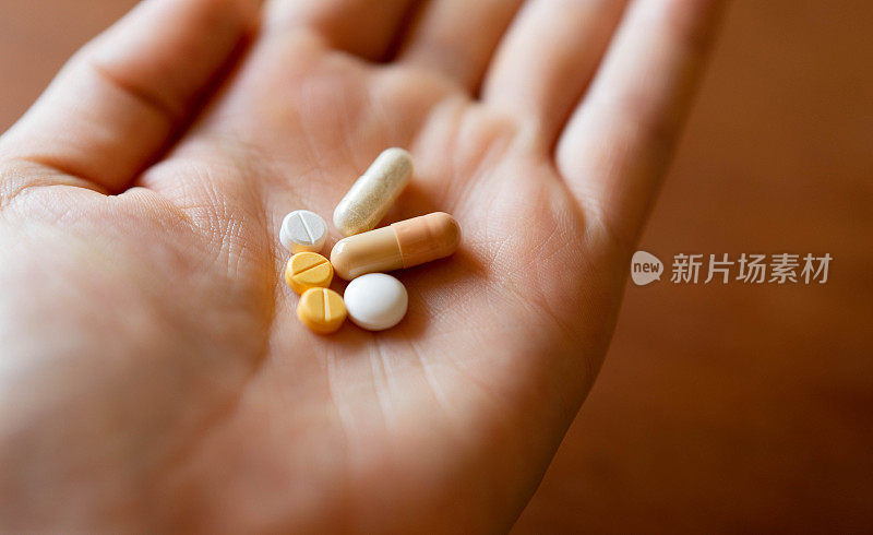 多种药物，包括药丸和胶囊，在病人的手掌。