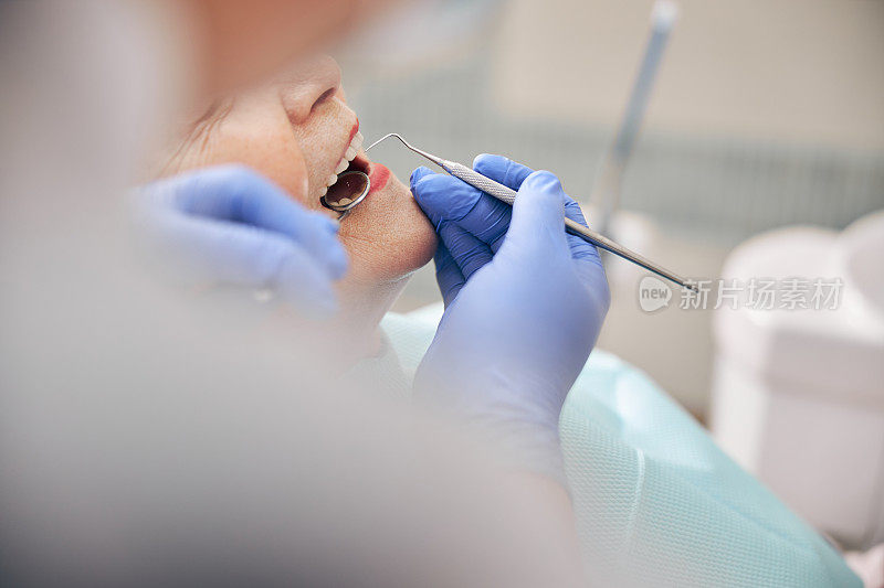 牙医用牙科工具检查病人的牙齿