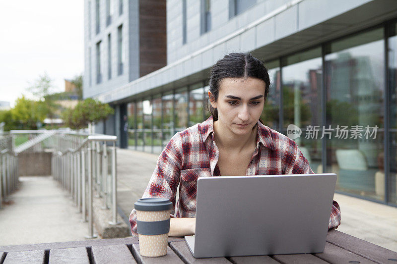 在校园里使用笔记本电脑的女大学生