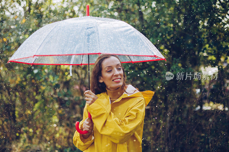 快乐的女人在雨中行走