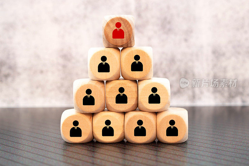 领导力和人力资源的概念与木块与商人的轮廓结构成一个金字塔。