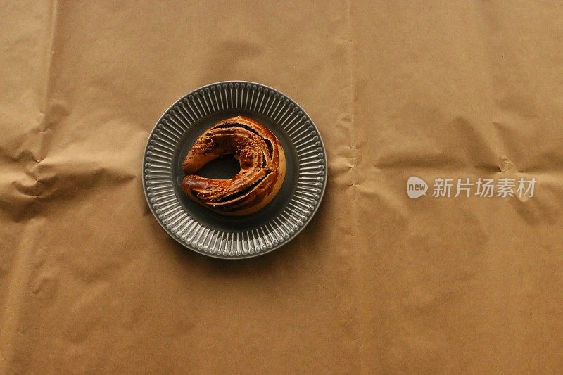 茶饼放在灰色的陶瓷盘子上，棕色的包装纸上