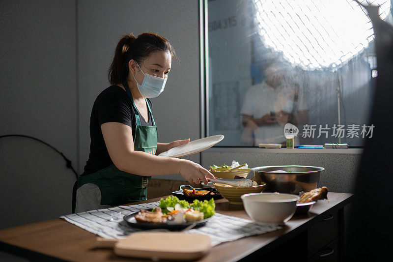 亚洲华裔女视频博主在她的家庭演播室播放装饰食品