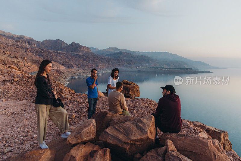 朋友旅行者在约旦的死海上观赏日落美景
