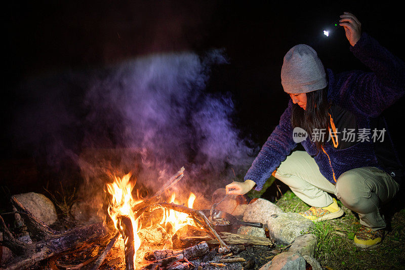 女营员在露天营火上做饭