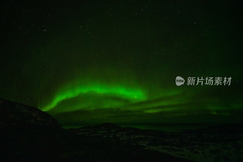 北极光在夜空中山脉的轮廓