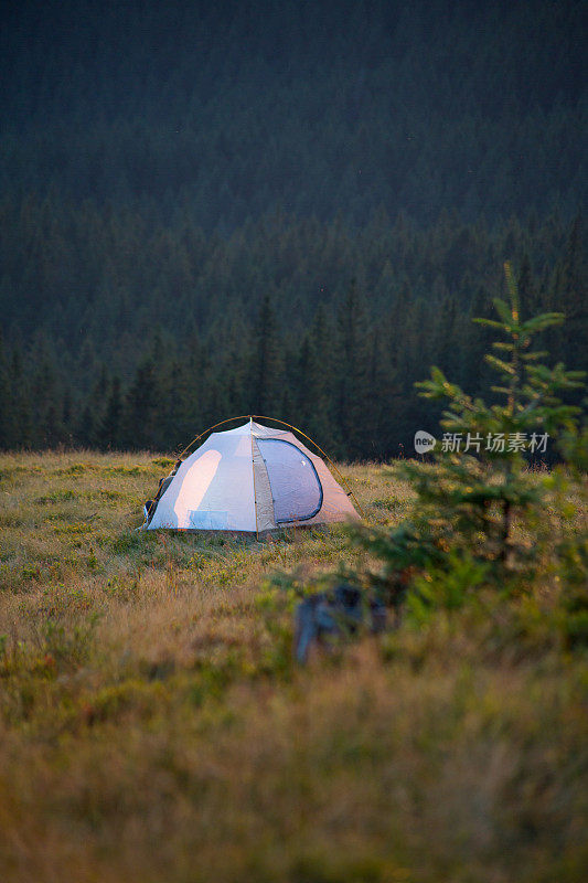 山腰上有森林背景的轻型帐篷