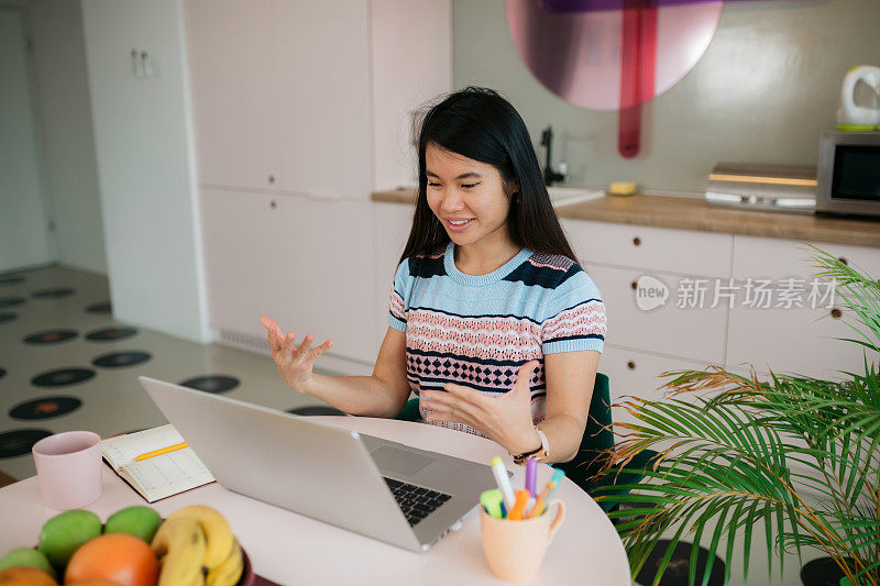 由于冠状病毒封锁，快乐的年轻东亚女性在家工作