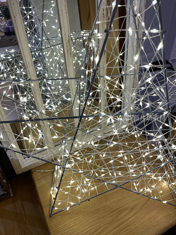 金属星形框架的特写，周围缠绕着仙女灯，做成一盏灯