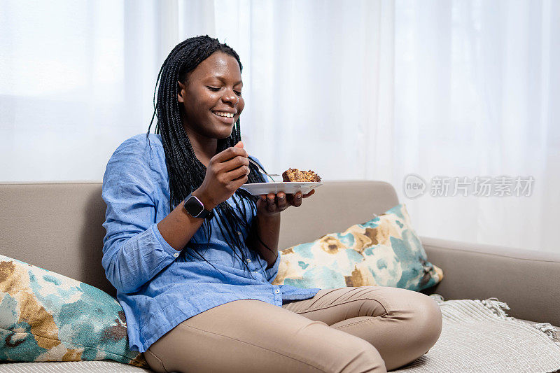 漂亮的女孩喜欢吃巧克力蛋糕。一个漂亮的年轻女人在吃一块甜蛋糕