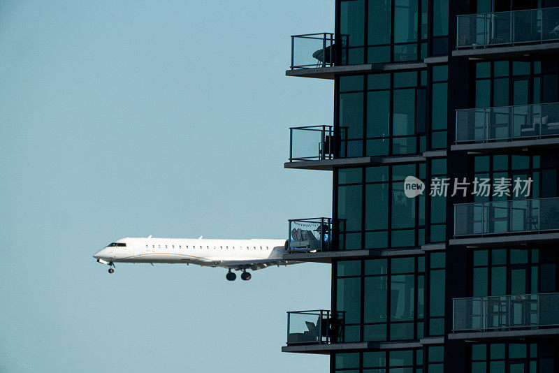 在一个阳光明媚的早晨，一架商用客机降落在圣地亚哥的高层建筑后面