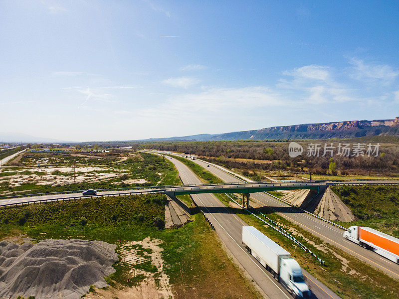 在东和西行车道的半卡车的车辆和半卡车驾驶在70号州际公路和美国西部的立交桥的无人机视图