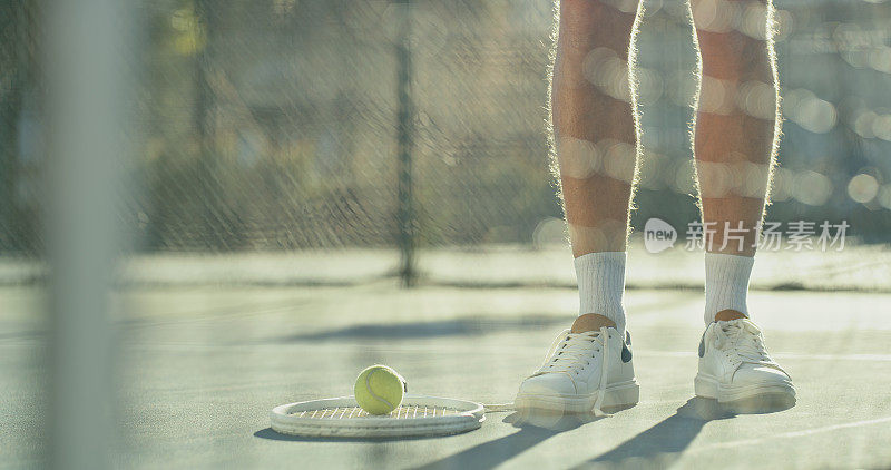 一个面目全非的人在户外球场打网球
