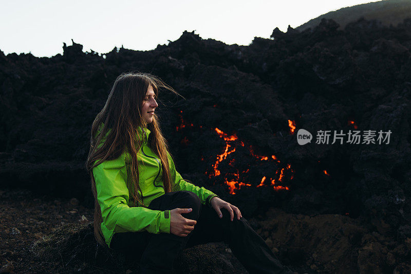 女游客探索戏剧性的火山景观与新鲜的熔岩在Fagradalsfjall，冰岛