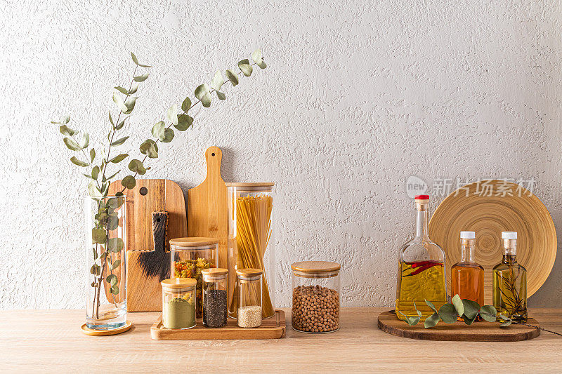 厨房台面上的一套不同灌装罐和瓶子。装饰存储区。砧板。环保储存。