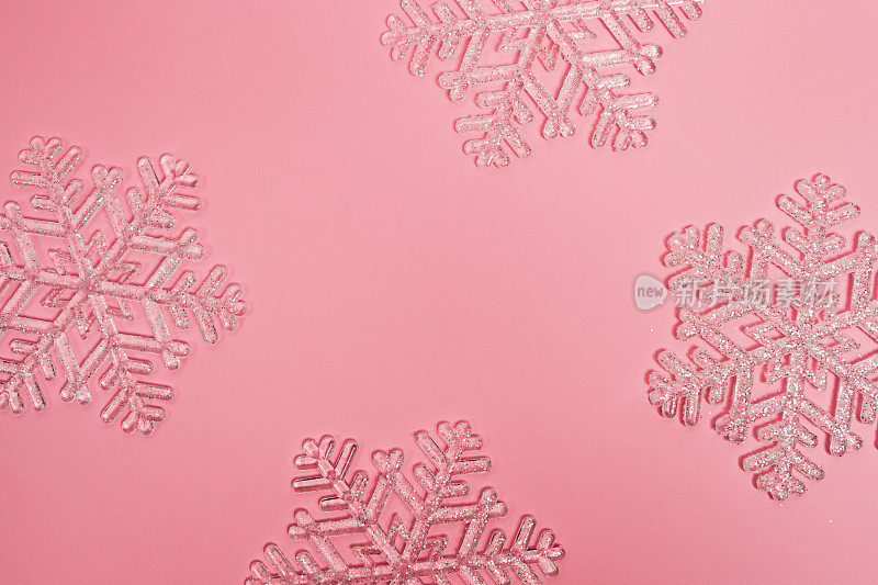粉红色的圣诞框架与水晶雪花。新年背景与复制空间