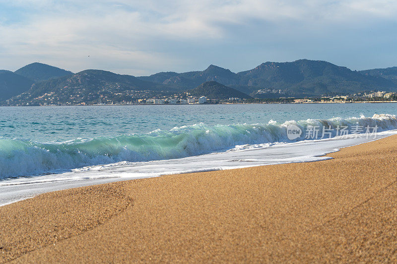 海浪在沙滩纹理背景，透明的海水，蓝天，阳光海岸