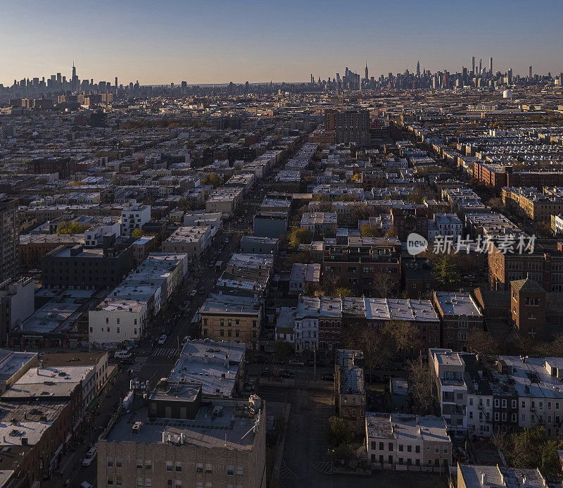纽约布鲁克林布什维克的住宅区，在阳光明媚的傍晚，背景是遥远的曼哈顿天际线。