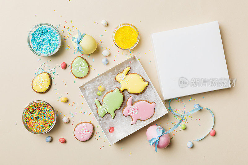 彩色复活节饼干在篮子与多种颜色复活节彩蛋在彩色背景。色彩柔和的彩蛋。假日概念与复制空间