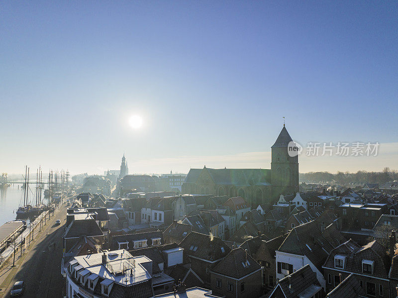 Kampen市Buitenkerk在寒冷的冬季日出时在IJssel河上的景色