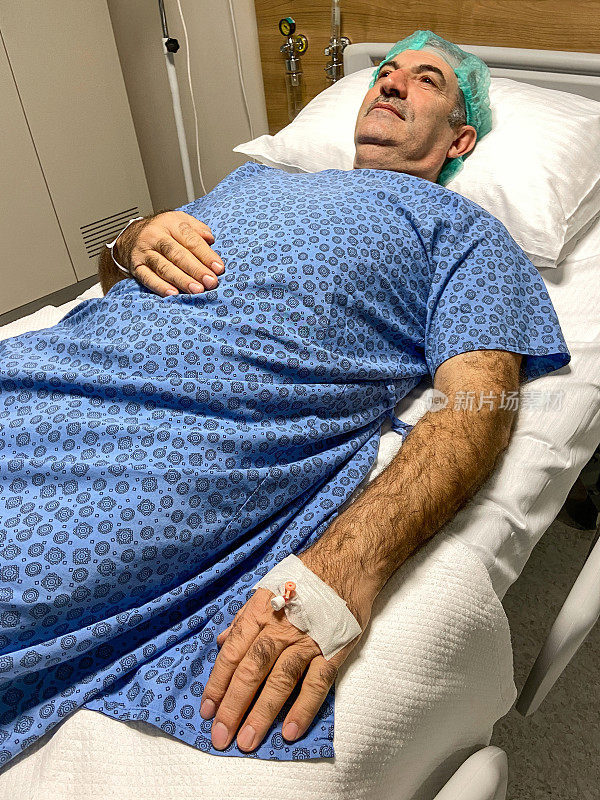 病人准备接受手术。在病房里，一位老人躺在病床上准备手术