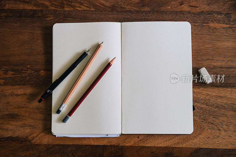垂直风格的空白速写本在木桌与蜡笔